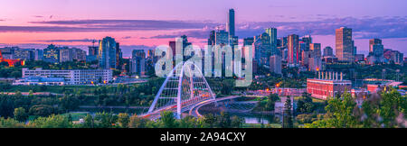 Skyline di Edmonton al tramonto con un bagliore rosa e. Il ponte di Walterdale che attraversa il fiume Saskatchewan nord nel Valle del fiume Foto Stock