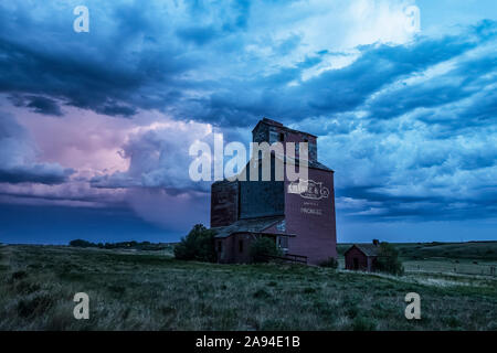 Elevatore di grano e tempesta sulle praterie; Saskatchewan, Canada Foto Stock