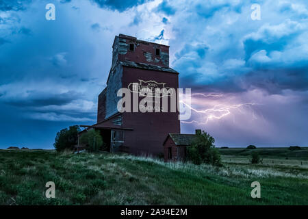 Ascensore di grano intemperie e tempesta elettrica sulle praterie; Saskatchewan, Canada Foto Stock