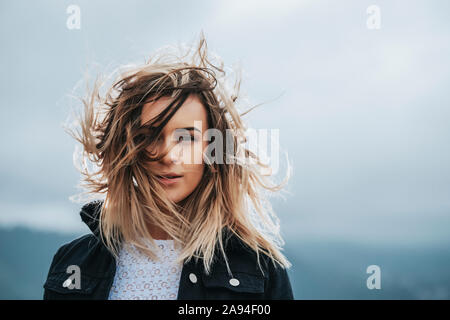 Ritratto di una bella giovane donna con capelli soffiati a vento; Wellington, Isola del Nord, Nuova Zelanda Foto Stock