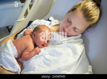 Neonato che dorme sul petto della madre in un letto d'ospedale; Vancouver, British Columbia, Canada Foto Stock