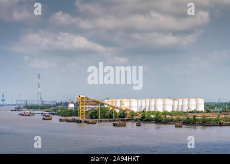 Lungo il fiume Tau, Vietnam - Marzo 12, 2019: Phuoc Khanh area. PetroVietnam alimentazione olio e il terminale con un folto gruppo di tnaks bianco. Banchine e sbarco doc Foto Stock