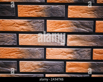 Orange facciata in mattoni. Strappata texture di pietra. Muro di pietra. sfondo astratto Foto Stock