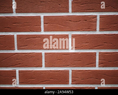 Orange facciata in mattoni. Strappata texture di pietra. Muro di pietra. sfondo astratto Foto Stock