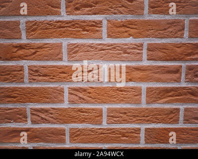 Orange facciata in mattoni. Strappata texture di pietra. Muro di pietra. sfondo astratto Foto Stock