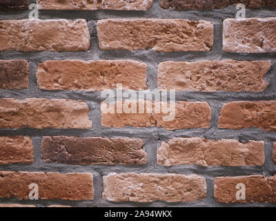 Orange facciata in mattoni. Strappata texture di pietra. Muro di pietra. sfondo astratto Foto Stock