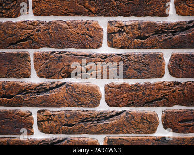 Orange facciata in mattoni. Strappata texture di pietra. Muro di pietra. sfondo astratto Foto Stock