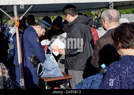 Domenica. Decimo Nov, 2019. Gli spettatori passano attraverso il controllo di sicurezza prima del Royal Parade per contrassegnare l'intronizzazione dell imperatore giapponese Naruhito in Tokyo, Giappone, domenica 10 novembre, 2019. Credito: AFLO/Alamy Live News Foto Stock