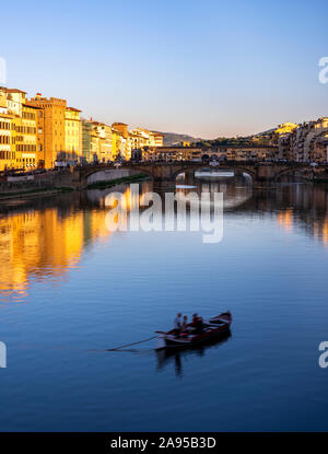 Firenze, Italia. Piccola barca sul fiume Arno al tramonto dal ponte alla Carraia. Foto Stock