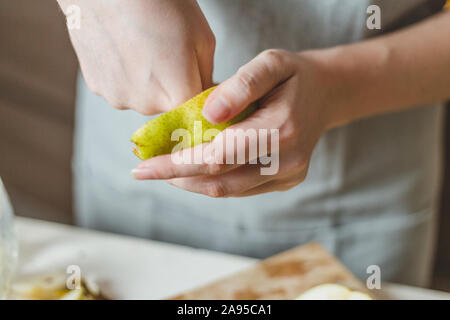 Affettare le pere in una insalata su una tavola di legno - ricetta casalinga - la casalinga con le mani in mano - rurali Foto Stock