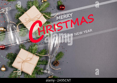 Felice anno nuovo , Xmas ninnolo con fatti a mano scatole regalo decorata con artigianato carta di Abete rami, due bicchieri di champagne, coriandoli su backgro scuro Foto Stock
