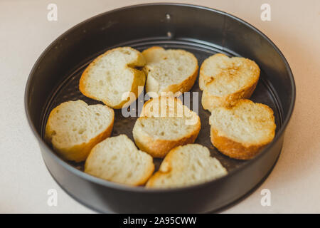 Primo piano della frittura casalinga baguette pezzi in una padella - facendo spuntini freddi - tapas e panini Foto Stock