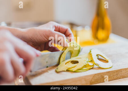 La donna si prepara il pranzo serve pane grigliato panino snack bruschette sul tagliere di legno, con insalata verde, la crema di formaggio, avocado - cibo sano Foto Stock