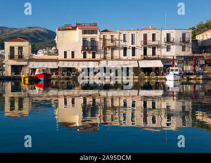 Rethymno, Creta, Grecia. Vista sul porto veneziano, la mattina presto, gli edifici si riflettono in acqua still. Foto Stock