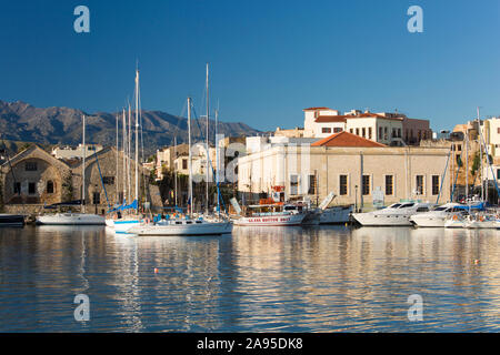 La Canea, Creta, Grecia. Vista sul porto vecchio, la mattina presto, edifici in riva al mare riflessi. Foto Stock