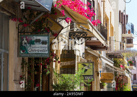 La Canea, Creta, Grecia. Vista lungo Odos Hatzimihali Daliani piena di fiori, negozi e ristoranti segni prominenti. Foto Stock
