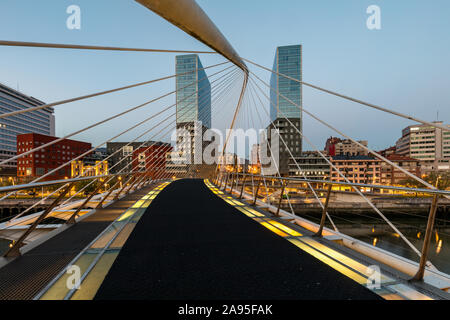 Dawn al ponte Zubizuri progettato da Santiago Calatrava oltre il fiume Nervion di Bilbao, Spagna, con il Isozaki Atea Twin towers Foto Stock