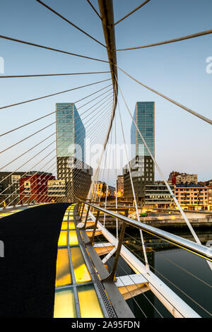 Dawn al ponte Zubizuri progettato da Santiago Calatrava oltre il fiume Nervion di Bilbao, Spagna, con il Isozaki Atea Twin towers Foto Stock