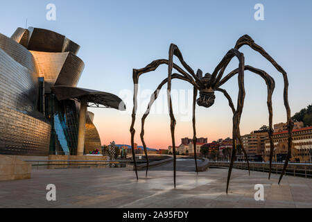 Maman spider scultura dell'artista Louise Bourgeois al di fuori del Museo Guggenheim appena dopo il tramonto, Nervión River, Bilbao, Paesi Baschi Foto Stock