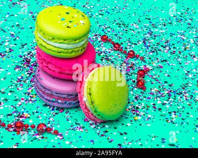 Amaretti colorati con colorati spruzza sul colore trend verde menta sfondo. close-up. Dolce gustoso cibo festoso Foto Stock