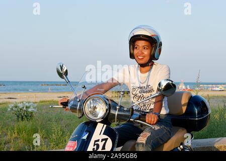 Donna su Vespa 125 Primavera nel porto di Penelope, Porto Senigallia Senigallia, provincia di Ancona, Italia Foto Stock