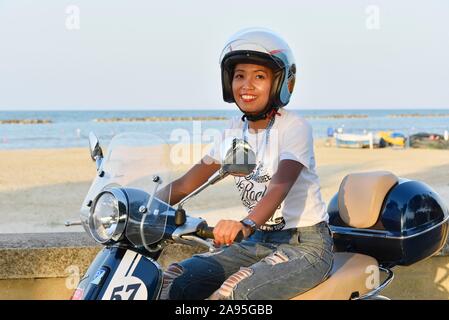 Donna su Vespa 125 Primavera nel porto di Penelope, Porto Senigallia Senigallia, provincia di Ancona, Italia Foto Stock