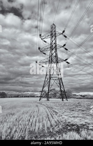 In bianco e nero (a infrarossi) immagine della rete elettrica piloni sotto un cielo rabbioso vicino a Cirencester Foto Stock