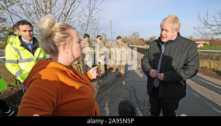 Il primo ministro Boris Johnson parla di una donna durante una visita a Stainforth, Doncaster, per vedere le recenti inondazioni. Foto Stock