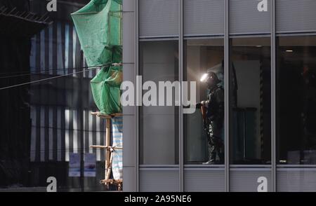 Hong Kong, Cina. Xiii Nov, 2019. Un tripudio di polizia, sentinella, look out insolito per il movimento a terra dall'interno della galleria di negozi durante il pranzo ora Flashmob protesta in Central.Nov-13, 2019 Hong Kong.ZUMA/Liau Chung-ren Credito: Liau Chung-ren/ZUMA filo/Alamy Live News Foto Stock