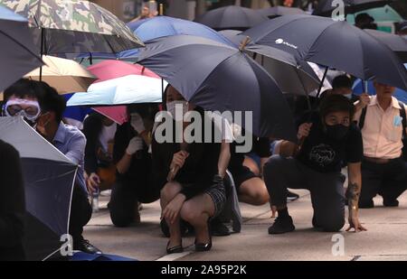 Hong Kong, Cina. Xiii Nov, 2019. Elegantemente vestito office lady, prendere parte all'ora di pranzo Flashmob protesta in centrale, occupando e bloccando il viale principale di fronte poliziotti antisommossa a dispetto.Nov-13, 2019 Hong Kong.ZUMA/Liau Chung-ren Credito: Liau Chung-ren/ZUMA filo/Alamy Live News Foto Stock