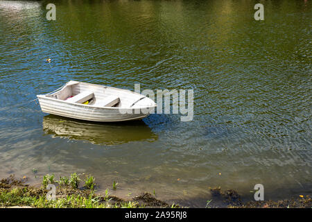 Solitaria barca da pesca galleggiante sul fiume Foto Stock