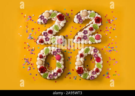2020 torta e ornamenti isolato su sfondo giallo. Anno nuovo concetto. Foto Stock