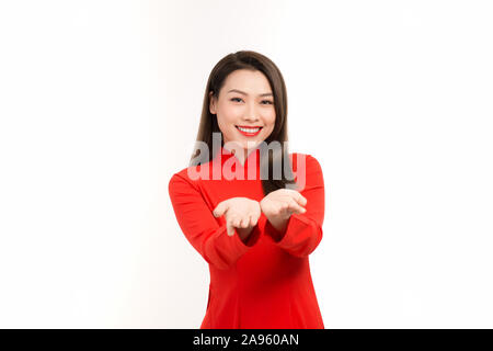 Sorridente donna asiatica ritratto in studio isolato su sfondo bianco che mostra qualcosa sul palmo della sua apertura di due mani per oggetto copia spazio. Foto Stock