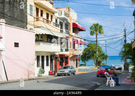 SANTO DOMINGO, REPUBBLICA DOMINICANA - 26 giugno 2019: uomo seduto e parlando al telefono nella zona coloniale della città. Tipico Sud Americana cityscape Foto Stock