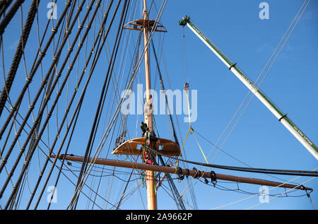 Il cantiere crossjack viene abbassata mediante gru dal mizzenmast sulla Corazzata Vittoriano HMS Warrior, ormeggiata a Portsmouth Historic Dockyard, le navi a montanti e parte del suo bompresso devono essere rimossi per restauro essenziale a Portsmouth. Foto Stock