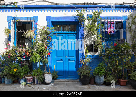 Asilah, Morocco-September 10, 2019: facciata di una casa tradizionale con un dipinto di blu porta e piante in vaso nella Medina di Asilah, Marocco Foto Stock