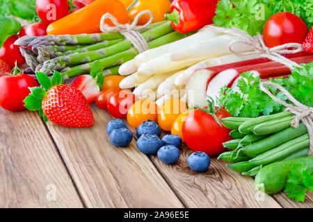 La frutta e la verdura fresca contro lo sfondo di legno Foto Stock