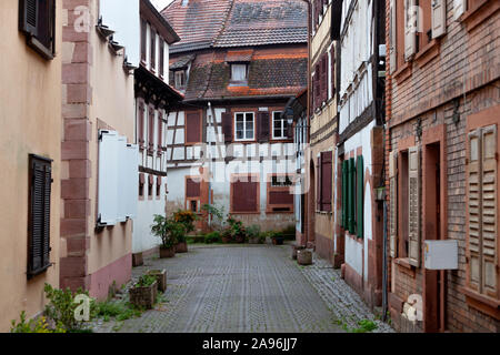 Strada bagnata e pittoresche case in Wissembourg Francia Foto Stock