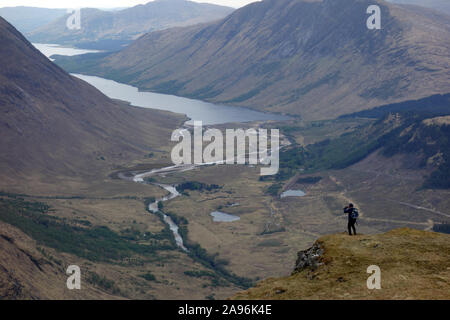 Uomo solitario di scattare le foto sulla montagna scozzese Corbett Stob Dubh (Beinn Ceitein) in Glen Etive, Highlands scozzesi, Scotland, Regno Unito. Foto Stock