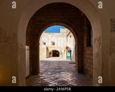 Arco in un tunnel scuro con segno di volo nella pittoresca città vecchia di Gallipoli, una bella meta di viaggio in Puglia, Italia Foto Stock