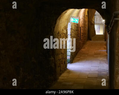 Arco in un tunnel scuro con segno di volo nella pittoresca città vecchia di Gallipoli, una bella meta di viaggio in Puglia, Italia Foto Stock