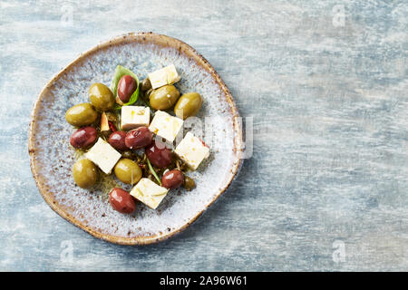 Verde e olive kalamata, capperi e formaggio feta in legno rustico sfondo. Snack sani Idea. Vista dall'alto. Copia dello spazio. Foto Stock