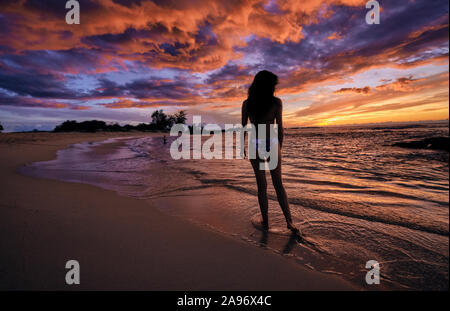 Una giovane donna cammina lungo la spiaggia Makalawena sulla Big Island delle Hawaii Foto Stock