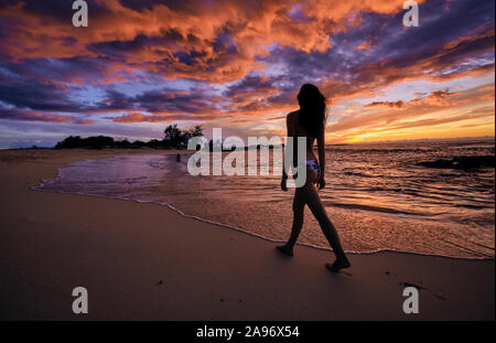 Una giovane donna cammina lungo la spiaggia Makalawena sulla Big Island delle Hawaii Foto Stock