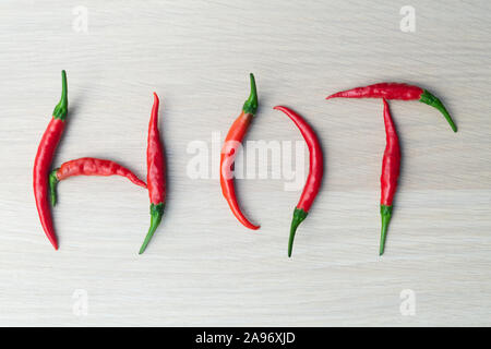 Red Hot Chili Peppers isolati su luce sullo sfondo di legno con iscrizione fatta a caldo con peperoncino. Foto Stock