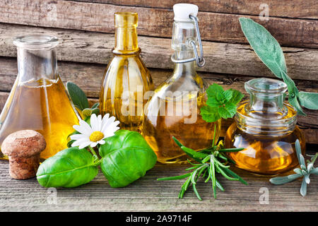Olio ed erbe su tavola di legno Foto Stock