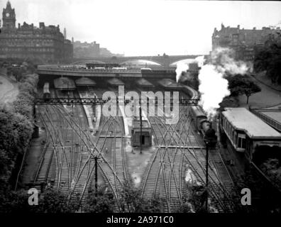 Un treno a vapore lascia la stazione di Edimburgo sulla 1940s. Una vista ad alto angolo che mostra tutte le linee ferroviarie e il North British Station Hotel in lontananza Foto Stock