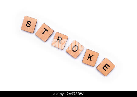 La parola Stroke, farro con lettera in legno piastrelle su uno sfondo bianco. Una corsa è una condizione medica in cui scarso flusso di sangue al cervello risultati Foto Stock