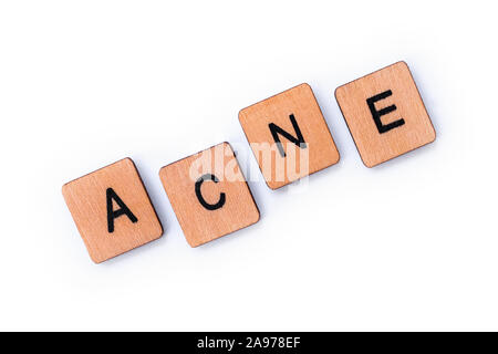 La parola acne, farro con lettera in legno piastrelle su uno sfondo bianco. Foto Stock