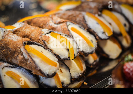 deliziose delizie italiane - piatto di canoli con panna fresca, frutta secca, pistacchio e cioccolato Foto Stock